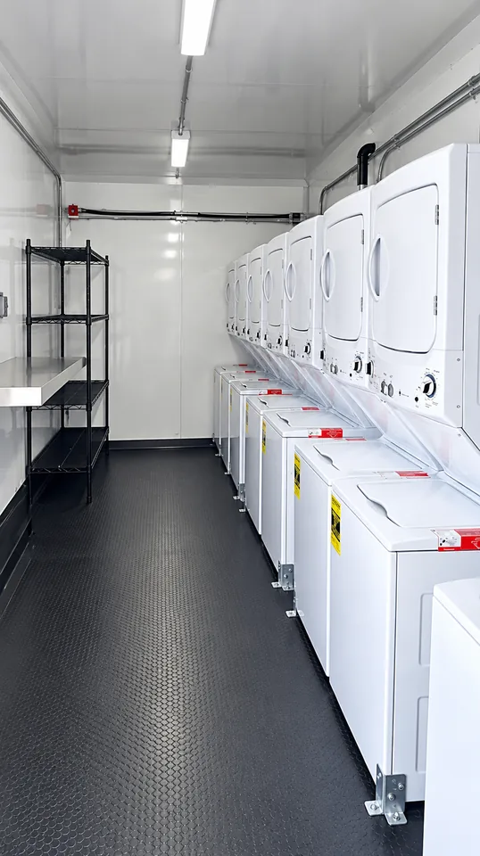 Commercial washers and dryers inside a 30 ft mobile laundry trailer