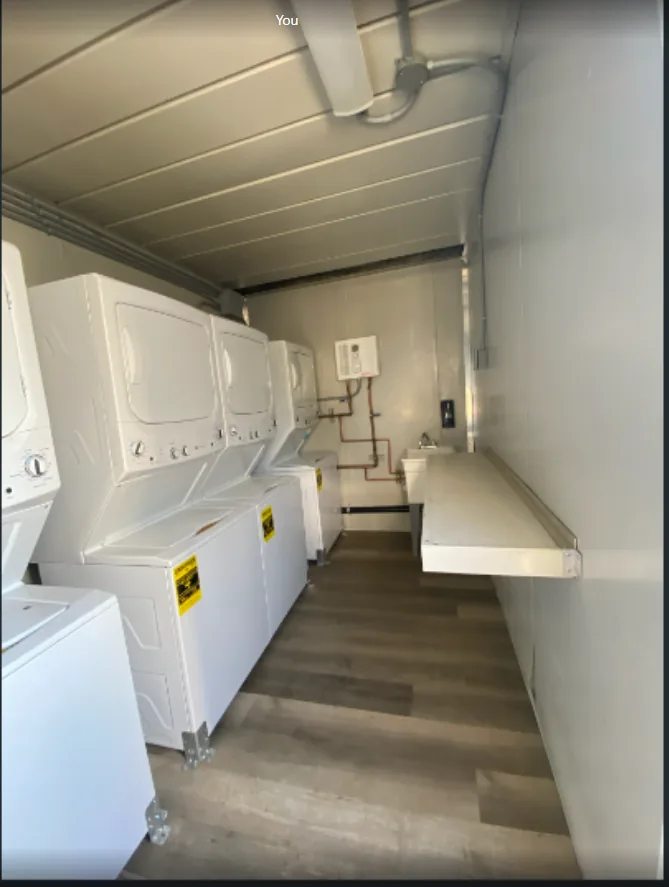 Washers and dryers inside a portable mobile laundry trailer for workforce housing